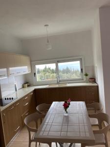a kitchen with a table with a vase of flowers on it at Suzi's apartment in Dhërmi +17 photos