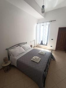 una camera da letto con un letto con due asciugamani sopra di Dimora Nuccio a Martina Franca