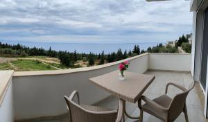 a table and chairs on a balcony with a view at Suzi's apartment in Dhërmi