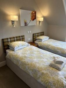 um quarto com 2 camas e toalhas em Corunna Bed & Breakfast and Garden Cottage em Inverness