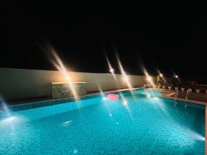 uma grande piscina à noite com um frisbee em Eminence The Corbett em Jhirna