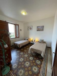 a room with two beds and a rug at La Casa di Alex - Alex's House in Colle Val D'Elsa