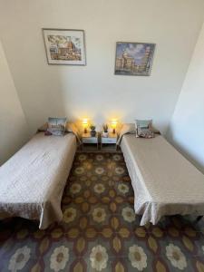 una habitación con dos camas en una habitación en La Casa di Alex - Alex's House, en Colle Val D'Elsa