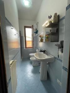 a white bathroom with two sinks and a toilet at La Casa di Alex - Alex's House in Colle Val D'Elsa