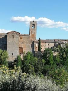 un antiguo edificio con una torre de reloj en una colina en La Casa di Alex - Alex's House, en Colle Val D'Elsa