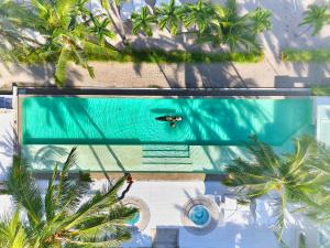 an overhead view of a swimming pool with palm trees at Seven Secrets by Hanging Gardens in Senggigi 