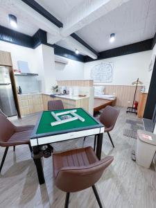 a room with a table and chairs and a kitchen at 小城門 親子寵物包棟民宿 City Door Family and Pet-Friendly Entire Homes in Tainan