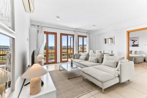 a living room with a couch and a table at Apartment Theia with sea and sunset views, the Resort in Aphrodite Hills in Kouklia