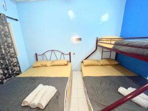 two bunk beds in a room with blue walls at Memory Lane Tioman in Tioman Island