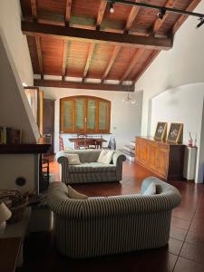 een woonkamer met 2 banken en een tafel bij Charming Villa in Monferrato in Camino