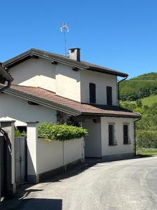 une maison blanche avec un portail et une allée. dans l'établissement Charming Villa in Monferrato, à Camino
