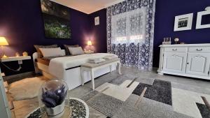 - une chambre avec des murs violets, un lit et une table dans l'établissement Studio apartman Marta, à Korenica