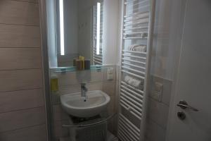 a small bathroom with a sink and a mirror at Einraumapartment im Erdgeschoss mit Seeblick in Rheinsberg