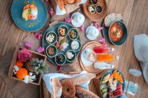 una mesa de madera con platos de comida. en Seven Secrets by Hanging Gardens en Senggigi 