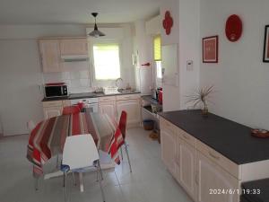 a kitchen with a table and chairs in a room at Joli T2 Socoa Urrugne 900m de la mer in Urrugne