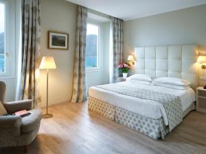 1 dormitorio con 1 cama grande y 1 silla en Hotel Du Lac & SPA en Bellagio