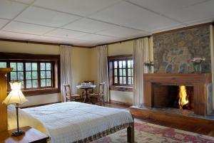 una camera da letto con camino, letto e tavolo di Mukima Manor a Nanyuki