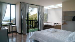 a bedroom with a bed and a view of a balcony at Finca Hotel Los Alpes in Manizales