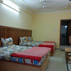 デヘラードゥーンにあるHotel Rajpal Guest Houseのベッドルーム(ベッド2台、テレビ付)