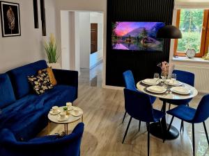 a living room with a blue couch and a table at Apartament Mountains Góry Sowie in Jugów
