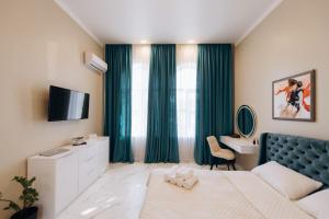 a bedroom with a bed and a desk and a television at Стильна та сучасна квартира в Центрі in Ternopil