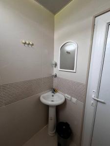 a white bathroom with a sink and a mirror at Guesthouse Turo in Ambrolauri +43 photos