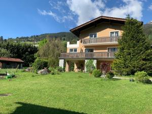 una grande casa con un ampio cortile con erba verde di Chalet Ester a Bad Hofgastein