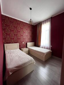 a bedroom with two beds and a window at Guesthouse Turo in Ambrolauri