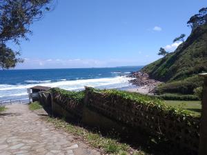 een pad dat leidt naar een strand met de oceaan bij Casa Bayona in Monte