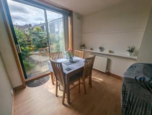 a dining room with a table and chairs and a window at Gorgeous Full Home in Edinburgh in Edinburgh