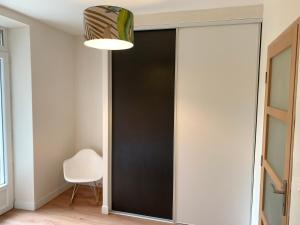 ArthèsにあるSuperbe T2 climatisé avec patio et jardinの白い椅子のある部屋の黒いドア