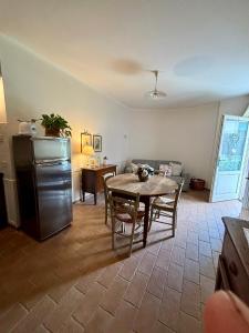 Il comprend une cuisine et un salon avec une table et un canapé. dans l'établissement La Magnolia B&B and apartaments, à Arrone