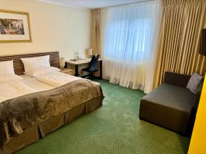 a hotel room with two beds and a desk at Hotel Residenz Stockstadt in Stockstadt am Main