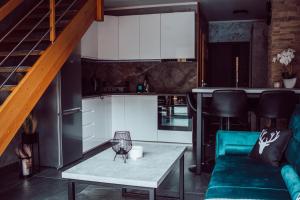 una sala de estar con un sofá y una mesa en Domki całoroczne Koczalski Chillout KASZUBY, en Koczała