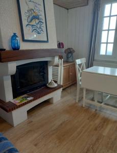 sala de estar con chimenea y mesa de comedor en Les chambres d'hôtes Le Val d'Honfleur, en Équemauville