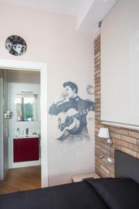 ein Schlafzimmer mit einem Wandbild eines Gitarrenspielers in der Unterkunft Little Rock Guest House in Gaeta