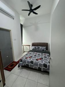 a bedroom with a bed and a ceiling fan at Acik Homestay in Pokok Sena