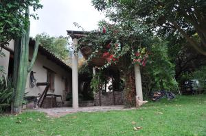 a house with a pergola with flowers on it at Valle Dorado Lodge in Cusco +90 photos