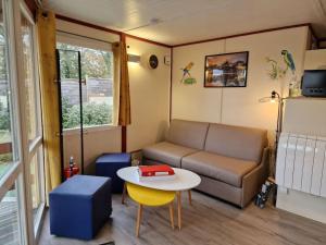 a small living room with a couch and a table at Gite proche Mont St Michel, Spa privatif en option ,St Malo in Saint-Marcan