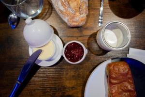 een tafel met een bord brood en een kop jam bij Lov'Infini in Mers-les-Bains