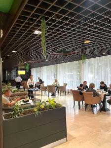 grupa ludzi siedzących przy stolikach w restauracji w obiekcie CORPUS A - Hotel Albatros w Ulcinju