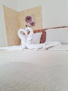 a bed with two swans made to look like towels at Apartmani SAMB Igalo in Herceg-Novi