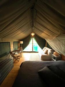 a room with a tent with a bed and a table at Eco Glamping Portugal Nature Lodge in São Luis