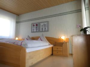 a bedroom with a bed with two lights and two tables at Gästehaus Bleser in Ernst