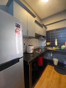 eine Küche mit einem weißen Kühlschrank und Holzböden in der Unterkunft PD Seaview Paradise Lagoon Apartment in Port Dickson