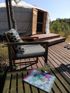 einen Stuhl und einen Tisch auf einer Terrasse mit Jurte in der Unterkunft Portugal Nature Lodge in São Luís