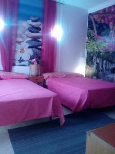 duas camas num quarto com lençóis cor-de-rosa em Santiago Mallorca em Cala Figuera