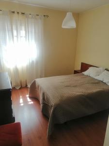 a bedroom with a bed and a window with a light at Casa da Estação in Sines