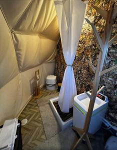 Podere Kiri Dome Experience في Decimomannu: حمام مع خيمة مع مرحاض وحوض استحمام