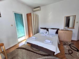 a bedroom with a bed with two towels on it at Apartmani SAMB Igalo in Herceg-Novi
